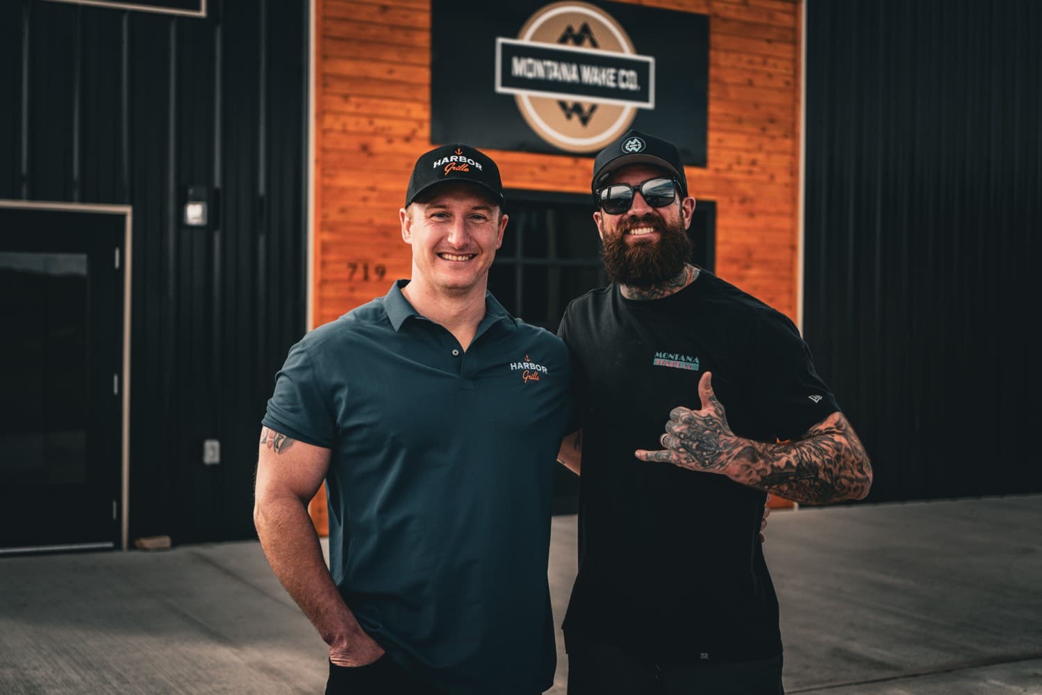 Two of the Montana Wake Co. crew outside the shop under the company sign.